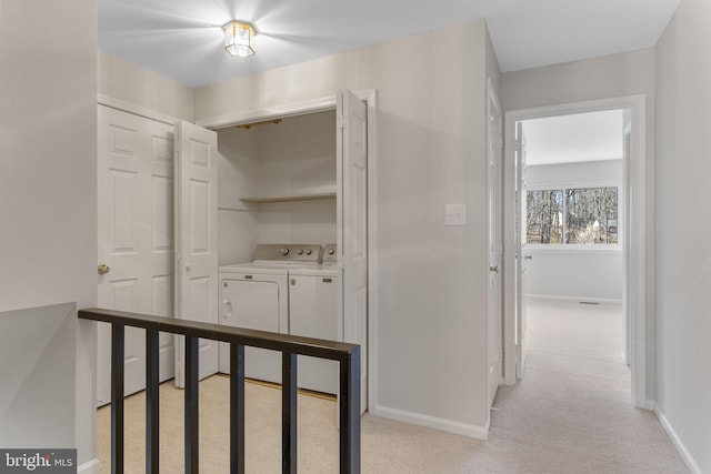 hall featuring washer and clothes dryer and light colored carpet