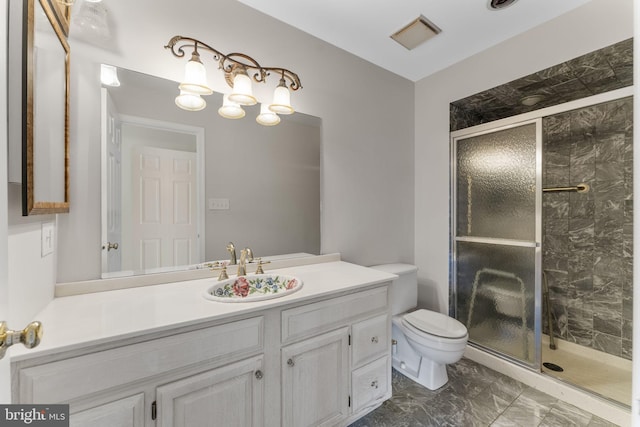 bathroom featuring vanity, a shower with door, and toilet