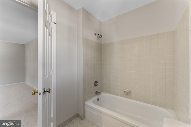 bathroom with tiled shower / bath combo and tile patterned flooring