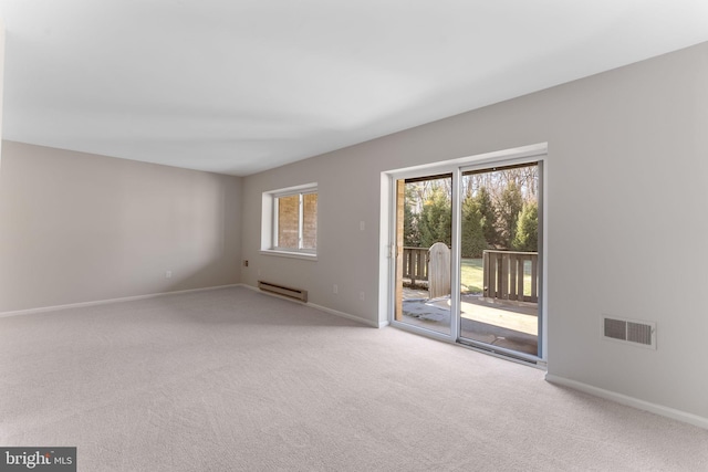 spare room with carpet flooring and a baseboard heating unit