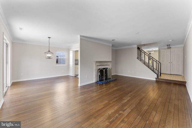 unfurnished living room featuring crown molding, dark wood-type flooring, and a notable chandelier