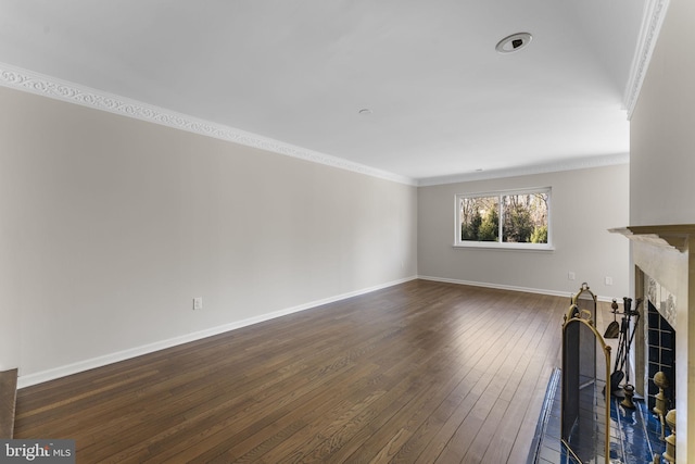 unfurnished living room featuring ornamental molding and dark wood-type flooring