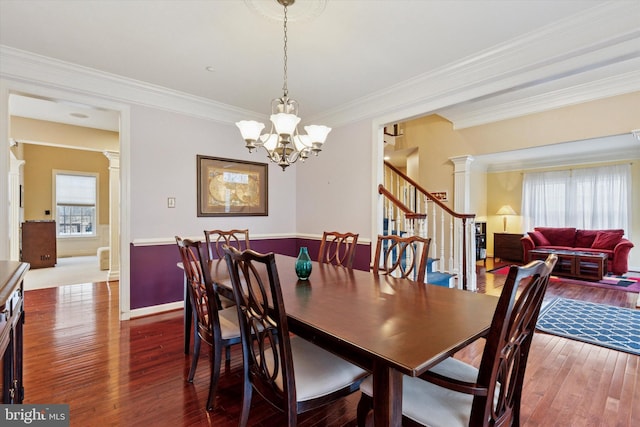 dining room with ornamental molding, stairway, hardwood / wood-style flooring, and decorative columns