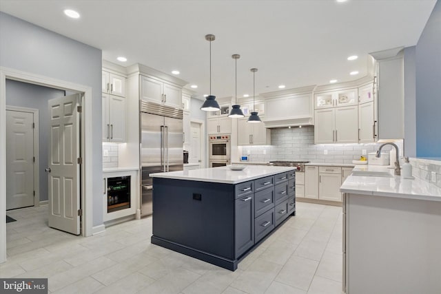 kitchen with beverage cooler, stainless steel appliances, a sink, white cabinetry, and light countertops