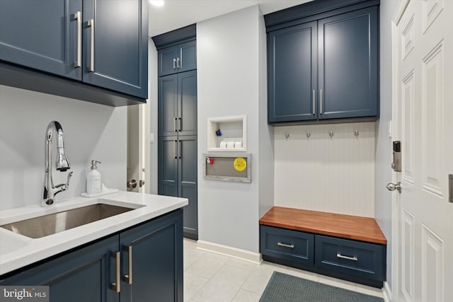 mudroom featuring light tile patterned floors, baseboards, and a sink