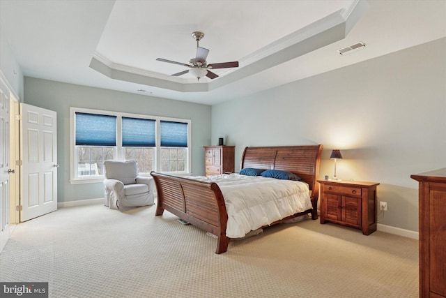 bedroom with crown molding, baseboards, a raised ceiling, and light colored carpet