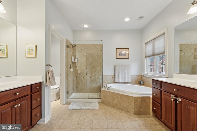 bathroom featuring toilet, vanity, visible vents, a shower stall, and a bath