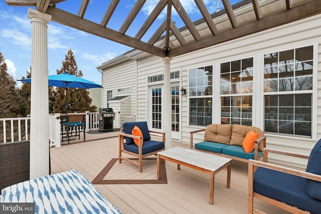 deck featuring a grill, an outdoor hangout area, and a pergola