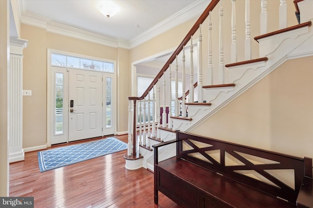 foyer with baseboards, stairway, wood-type flooring, and crown molding