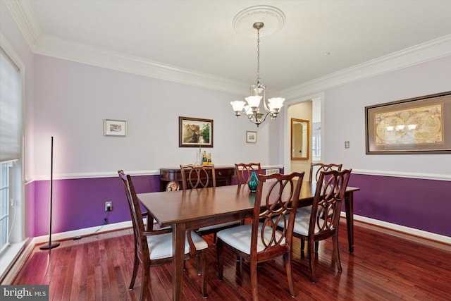 dining room with baseboards, hardwood / wood-style floors, and crown molding