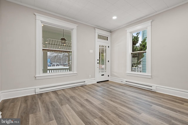 foyer featuring crown molding, a baseboard heating unit, and light hardwood / wood-style floors