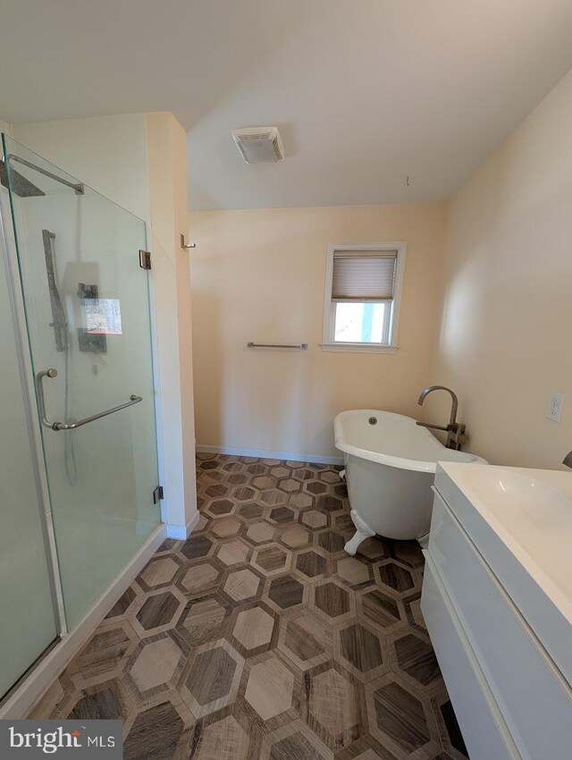 bathroom with vanity and separate shower and tub