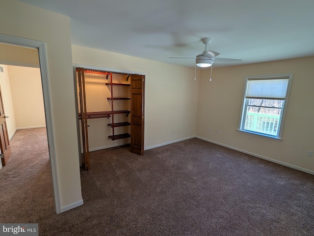 unfurnished bedroom with dark carpet, a closet, and ceiling fan