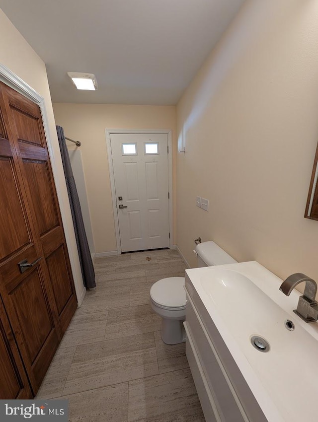 bathroom featuring vanity, curtained shower, and toilet