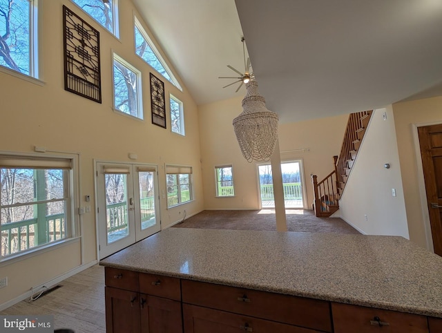 kitchen with an inviting chandelier, a towering ceiling, and french doors