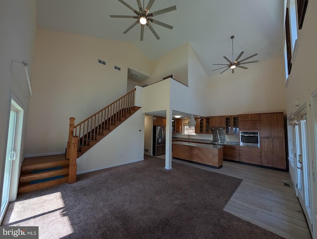 kitchen with ceiling fan, plenty of natural light, oven, and black fridge with ice dispenser
