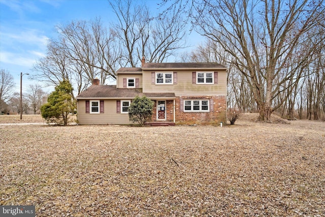 traditional home featuring brick siding and a chimney