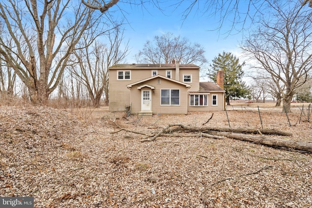 rear view of property with entry steps and a chimney