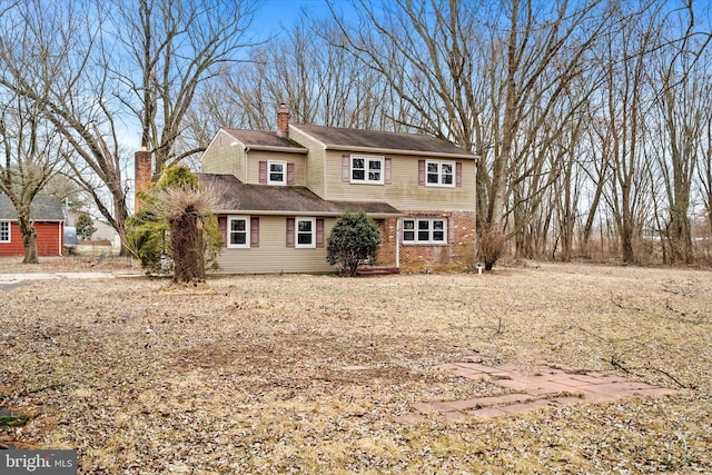 traditional home with a chimney and brick siding