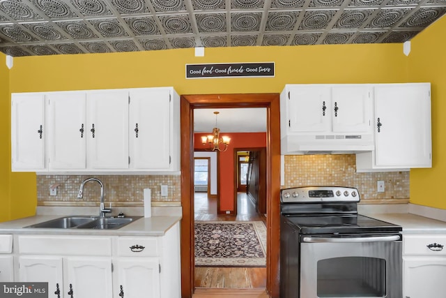 kitchen featuring sink, electric range, and white cabinets