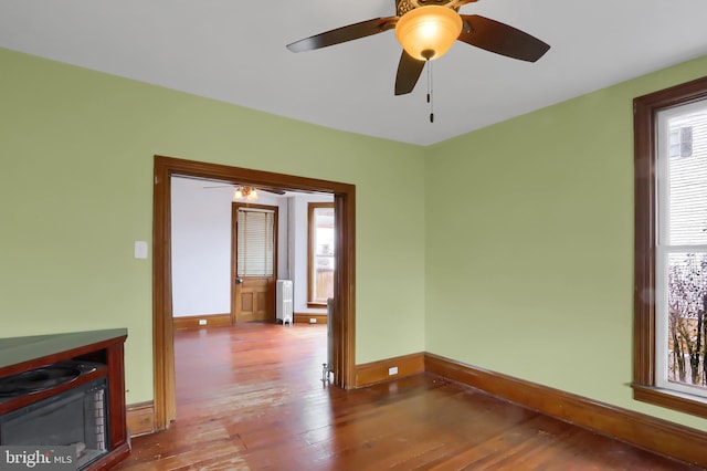 spare room featuring wood-type flooring and radiator heating unit