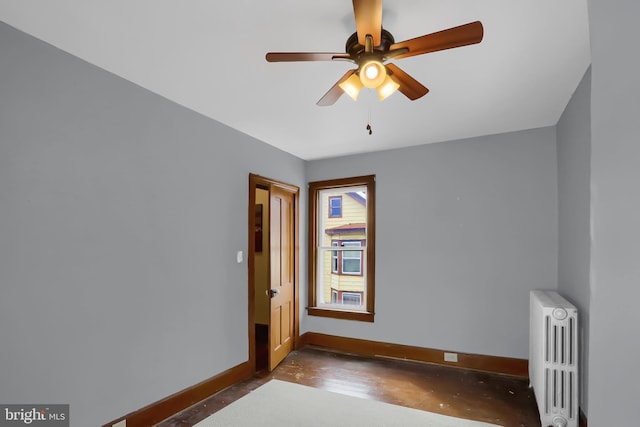 spare room with ceiling fan and radiator heating unit