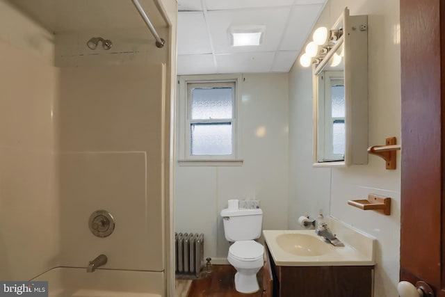 full bathroom with radiator, washtub / shower combination, vanity, a drop ceiling, and toilet