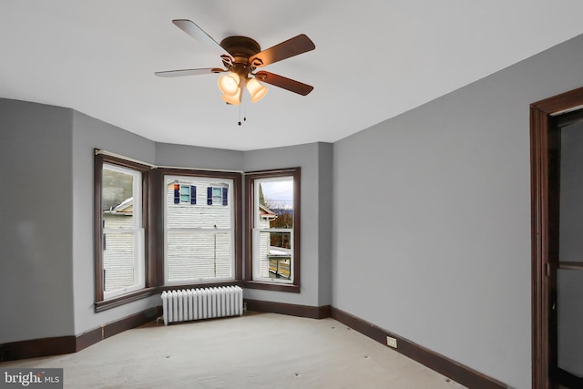 empty room with radiator heating unit, light colored carpet, and ceiling fan