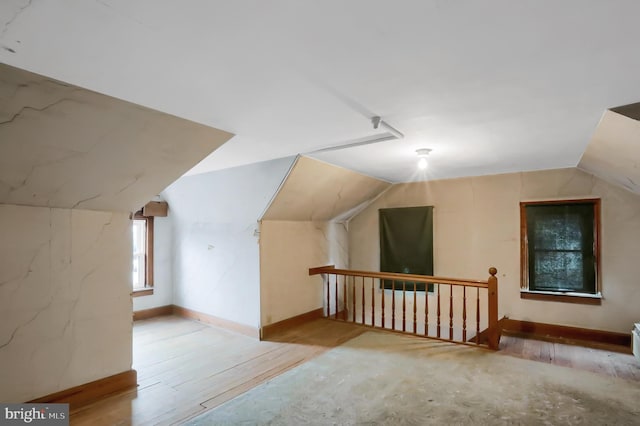 bonus room with lofted ceiling and hardwood / wood-style flooring