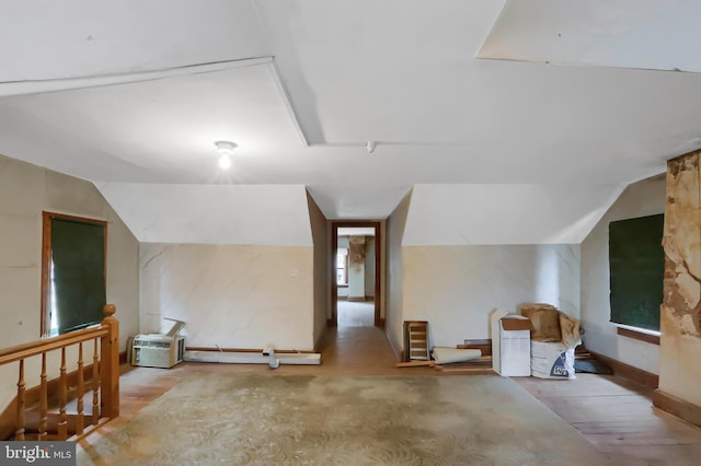 additional living space with lofted ceiling and hardwood / wood-style flooring