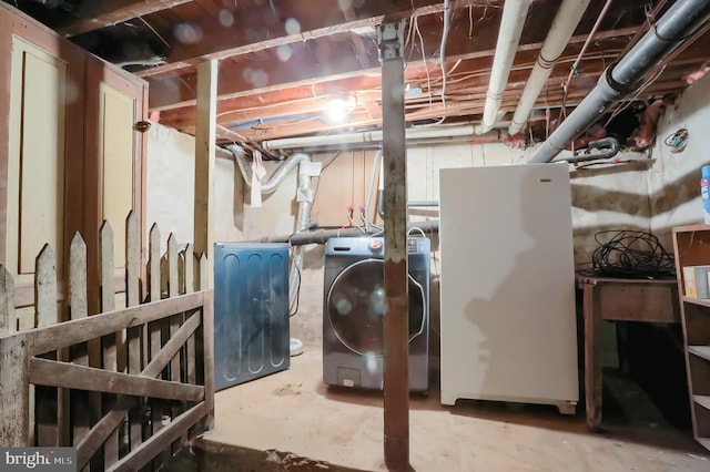 basement with independent washer and dryer and white fridge