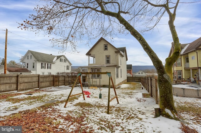 snow covered property featuring a playground