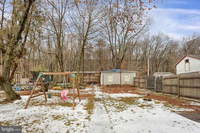 yard covered in snow featuring a shed and a playground