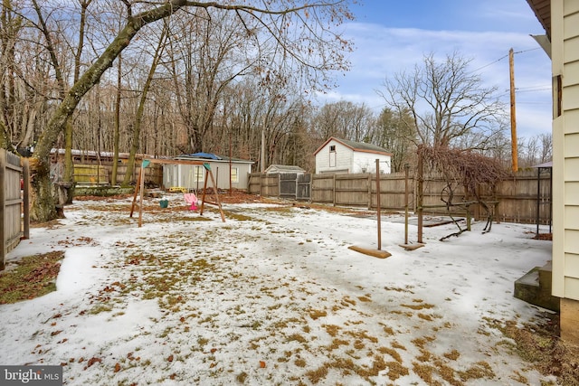 yard layered in snow with a storage unit