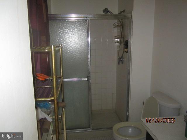 full bath featuring a shower stall and toilet