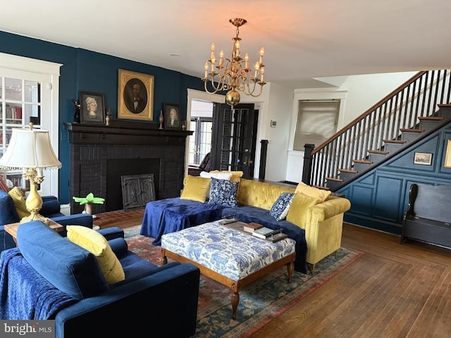 living room with dark hardwood / wood-style flooring, a fireplace, and an inviting chandelier