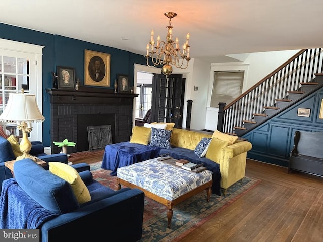 living room with dark hardwood / wood-style floors, a fireplace, and a notable chandelier