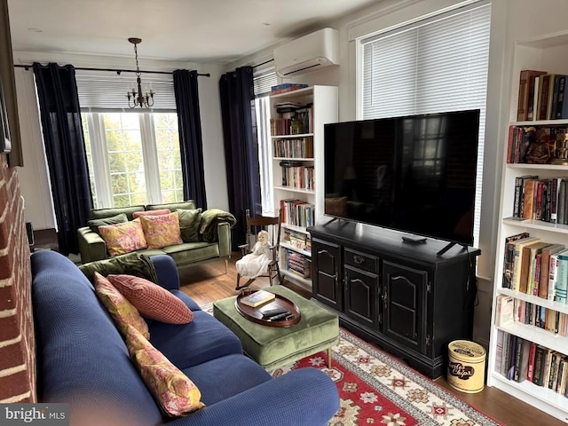 living room featuring hardwood / wood-style flooring, a wall mounted air conditioner, and a chandelier