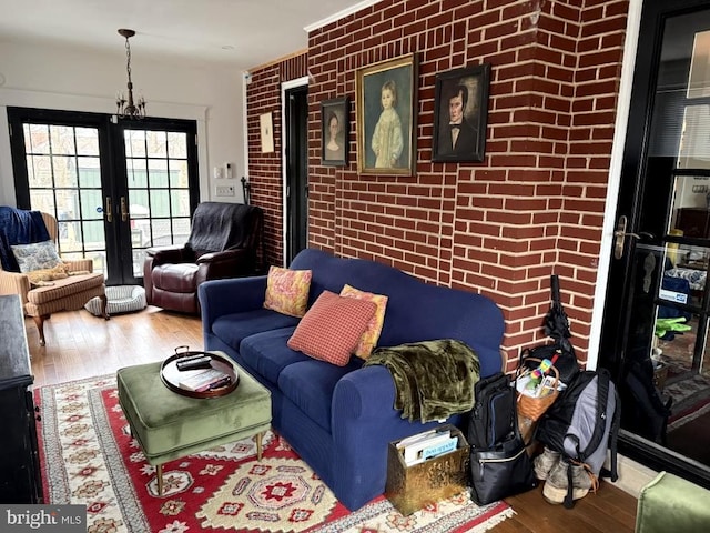 living room featuring wood-type flooring and brick wall