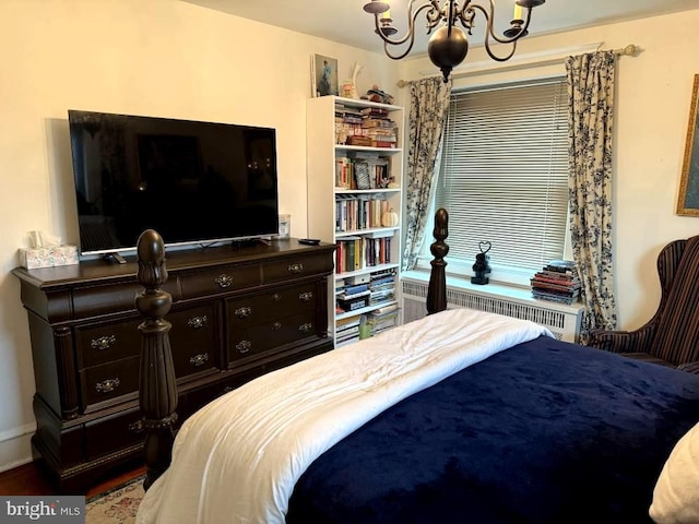 bedroom featuring radiator heating unit and a notable chandelier