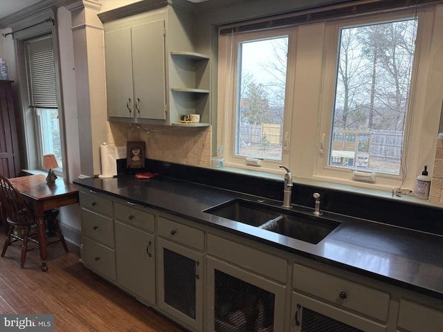 kitchen featuring tasteful backsplash, wood-type flooring, and sink