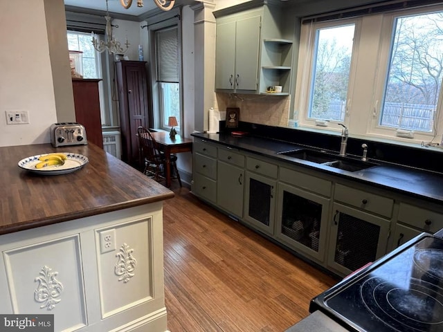 kitchen featuring sink, gray cabinets, a notable chandelier, light hardwood / wood-style floors, and decorative light fixtures