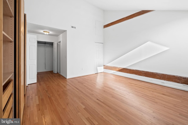 interior space with light wood-style floors, visible vents, and high vaulted ceiling