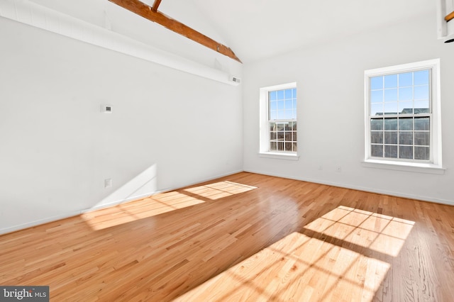 empty room with vaulted ceiling and wood finished floors