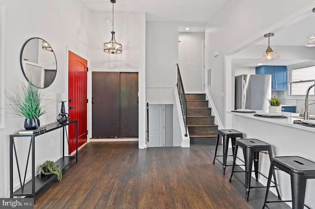 entryway featuring stairs, a high ceiling, and dark wood finished floors