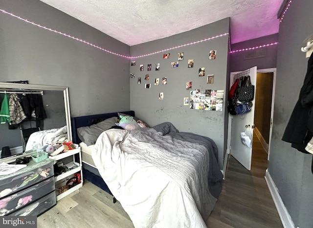 bedroom featuring wood-type flooring and a textured ceiling