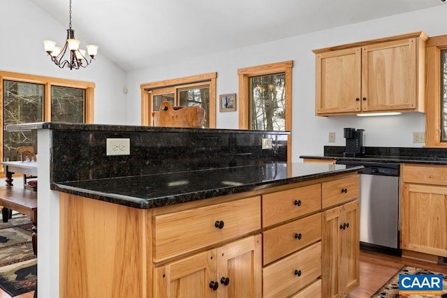 kitchen with dishwasher, dark stone countertops, light brown cabinetry, decorative light fixtures, and vaulted ceiling