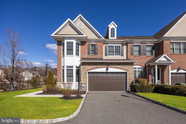 view of front of property with brick siding, stone siding, driveway, and a front lawn