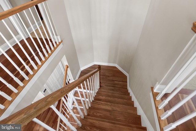 stairs with wood finished floors and baseboards