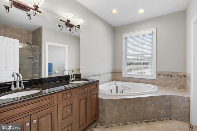 bathroom with tile patterned flooring, a tile shower, a garden tub, and a sink